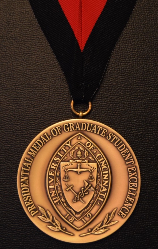 A medal with the university seal hanging on a black and red ribbon.